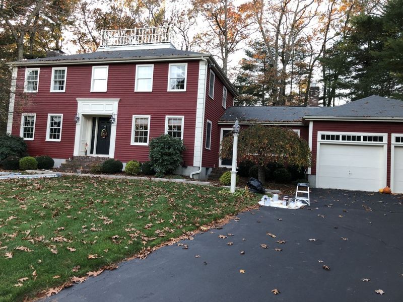 Colonial house with a fresh red exterior repaint and white trim