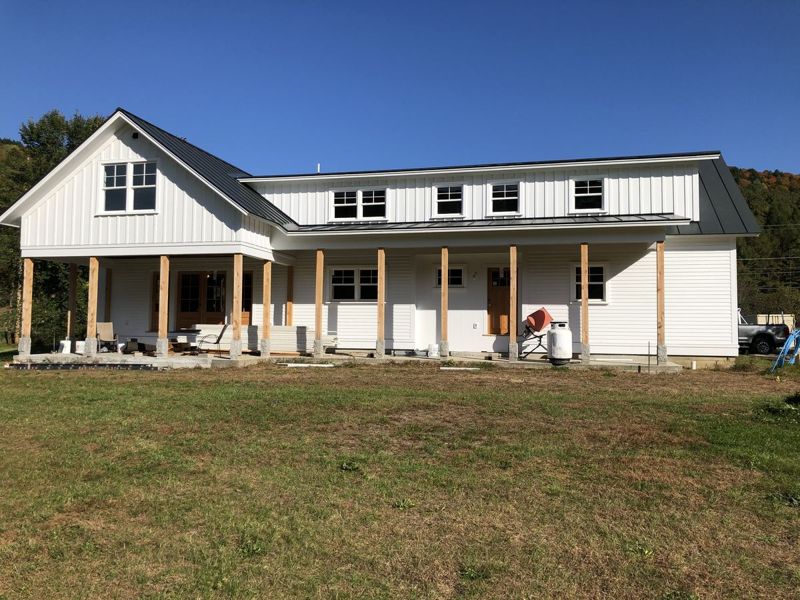 Farmhouse with a fresh white exterior repaint (After)