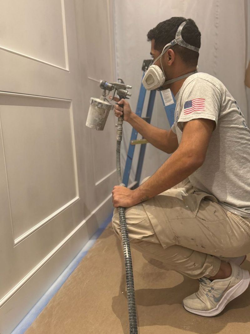 Israel Duarte spray painting on a job site